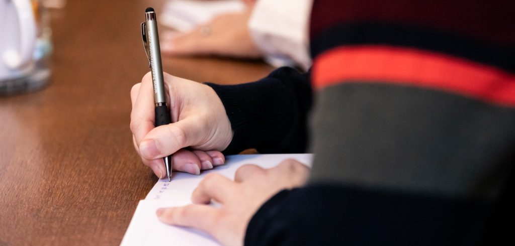 A training delegate writing down some clear outcomes in a notebook.